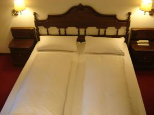 a bed with white sheets and pillows in a room at Regerhof in Germering +17 photos