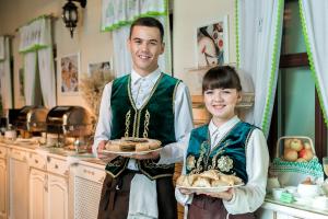 a man and a young girl holding plates of food at Tatarskaya Usadba in Kazan