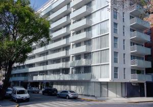 um grande edifício branco com carros estacionados em frente em Dazzler by Wyndham Polo em Buenos Aires