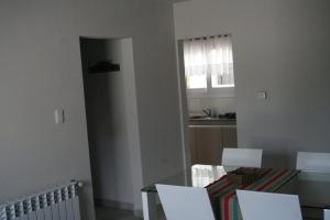 cocina con mesa, sillas y ventana en DEPARTAMENTO AZAHARES EN TANDIL en Tandil