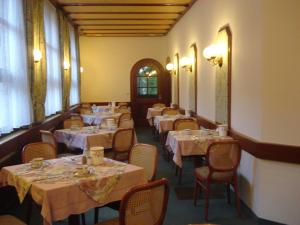 a row of tables in a dining room with white tablesearcher at Regerhof in Germering