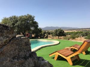 uma piscina com um banco e uma cadeira em Domo en Montes de Toledo em Mazarambroz