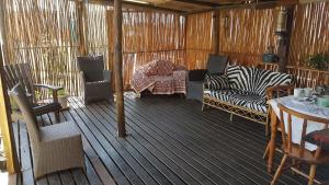 a screened in porch with furniture and a table at Eagle's Rest in Hartenbos