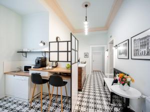 a kitchen and living room with a table and chairs at Art Deco Central Rooms in Lviv