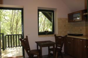 cocina con mesa, sillas y ventana en Hunor Lovastanya, en Kunbaracs