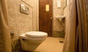 a small bathroom with a toilet and a shower at Treebo The Qasr in Cochin