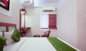 a bedroom with a large white bed with a window at Treebo The Qasr in Cochin