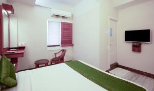 a hotel room with a bed and a television at Treebo The Qasr in Cochin