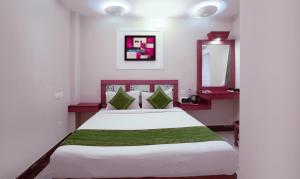 a bedroom with a large white bed and a mirror at Treebo The Qasr in Cochin