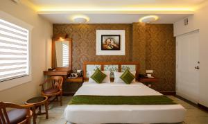 a hotel room with a bed and a table and chairs at Treebo The Qasr in Cochin