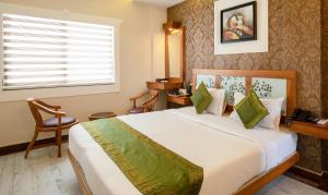 a bedroom with a large bed and a window at Treebo The Qasr in Cochin
