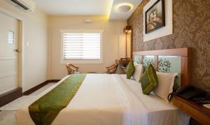 a bedroom with a large white bed in a room at Treebo The Qasr in Cochin