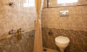 a bathroom with a toilet and a shower at Treebo The Qasr in Cochin