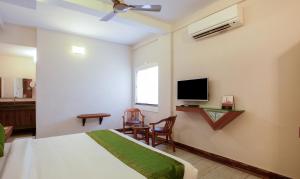 a bedroom with a bed and a flat screen tv at Treebo The Qasr in Cochin