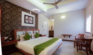 a bedroom with a large bed and a table and chairs at Treebo The Qasr in Cochin