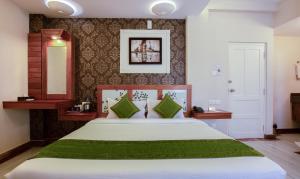 a bedroom with a large bed with green sheets at Treebo The Qasr in Cochin