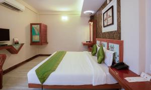 a bedroom with a large bed and a television at Treebo The Qasr in Cochin