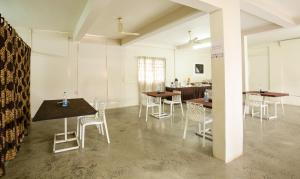 a room with tables and chairs and a kitchen at Treebo The Qasr in Cochin
