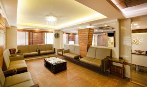 a living room with couches and a chandelier at Treebo Trend The Qasr in Cochin