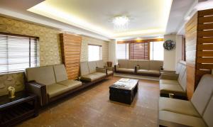 a waiting room with couches and a coffee table at Treebo The Qasr in Cochin