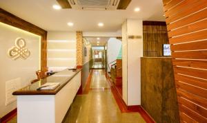 a kitchen with white walls and wooden floors at Treebo The Qasr in Cochin