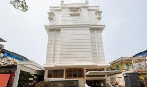 a white building with a tower on top of it at Treebo The Qasr in Cochin