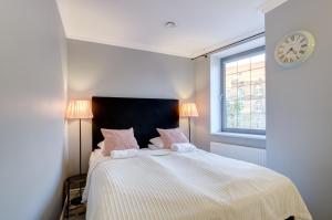 a bedroom with a bed with a clock on the wall at Happy Stay Old Town Tartaczna Str. 27A in Gdańsk