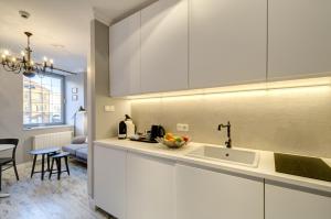 a kitchen with white cabinets and a sink at Happy Stay Old Town Tartaczna Str. 27A in Gdańsk