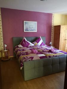 ツェル・アン・デル・モーゼルにあるFewo Winzerstrasseの紫の壁のドミトリールームのベッド1台分です。