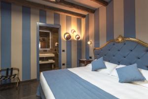 a bedroom with a bed and a striped wall at Hotel Tiziano in Venice