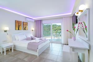 a white bedroom with a bed and a balcony at Dream View in Skala Marion