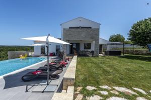 a swimming pool with a row of inflatables next to a house at Villa Meli in Sveti Lovreč Pazenatički