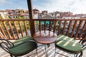 a table and chairs on a balcony with a view of the water at Celena Maisonettes in Arachova