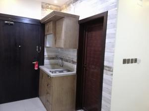una cucina con lavandino e porta in legno di Ramis Furnished Units a Buraydah
