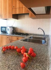 een bos rode bloemen op een aanrecht in een keuken bij Holidays Home Rivabella in Lezzeno