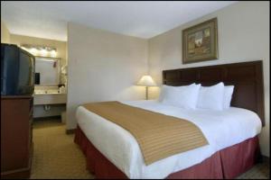 a hotel room with two beds and a television at Baymont by Wyndham Mobile/ I-65 in Mobile