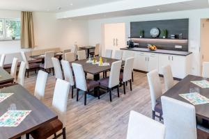 a dining room and kitchen with tables and chairs at Boardinghaus Bayerwaldpark in Landshut