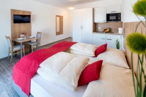 sypialnia z 2 łóżkami i czerwonymi poduszkami w obiekcie Boardinghaus Bayerwaldpark w mieście Landshut