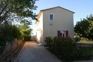 Saint-Pierre-de-Vassolsにある225 Chemin des Joncsの赤い扉と私道のある白い家