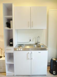 a kitchen with white cabinets and a sink at Appartement Centrum Domburg DO05 in Domburg +5 photos
