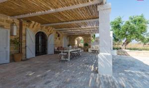 um pátio exterior com uma mesa e cadeiras em Masseria Curice em Corsano
