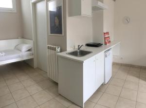 een witte keuken met een wastafel en een bad bij Affittacamere Italia Leonardo in Rho +22 foto's