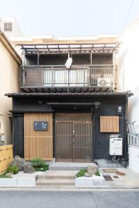 a black building with a gate and a balcony at Kujo Ume May In Higashikujo in Kyoto