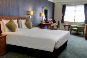 Habitación de hotel con cama grande y escritorio. en Best Western Thurrock Hotel en Grays Thurrock