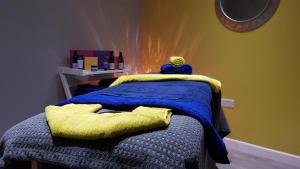 a bedroom with a bed with a blue and yellow blanket at LLety Cynin in Llangynin +90 photos