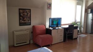 a living room with a chair and a television at Central Park Studio in Plovdiv