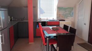 a kitchen with a table with red cabinets and a red table and chairs at Central Park Studio in Plovdiv