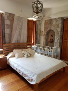 a bedroom with a large bed with a stone wall at Leonidio Stone House in Pragmatevtís