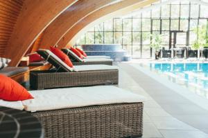 a room with wicker chairs and a swimming pool at Rönneberga in Lidingö