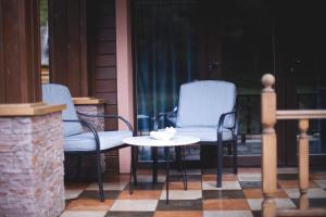two chairs and a table on a porch at Клуб Яремчанський Шале in Yaremche